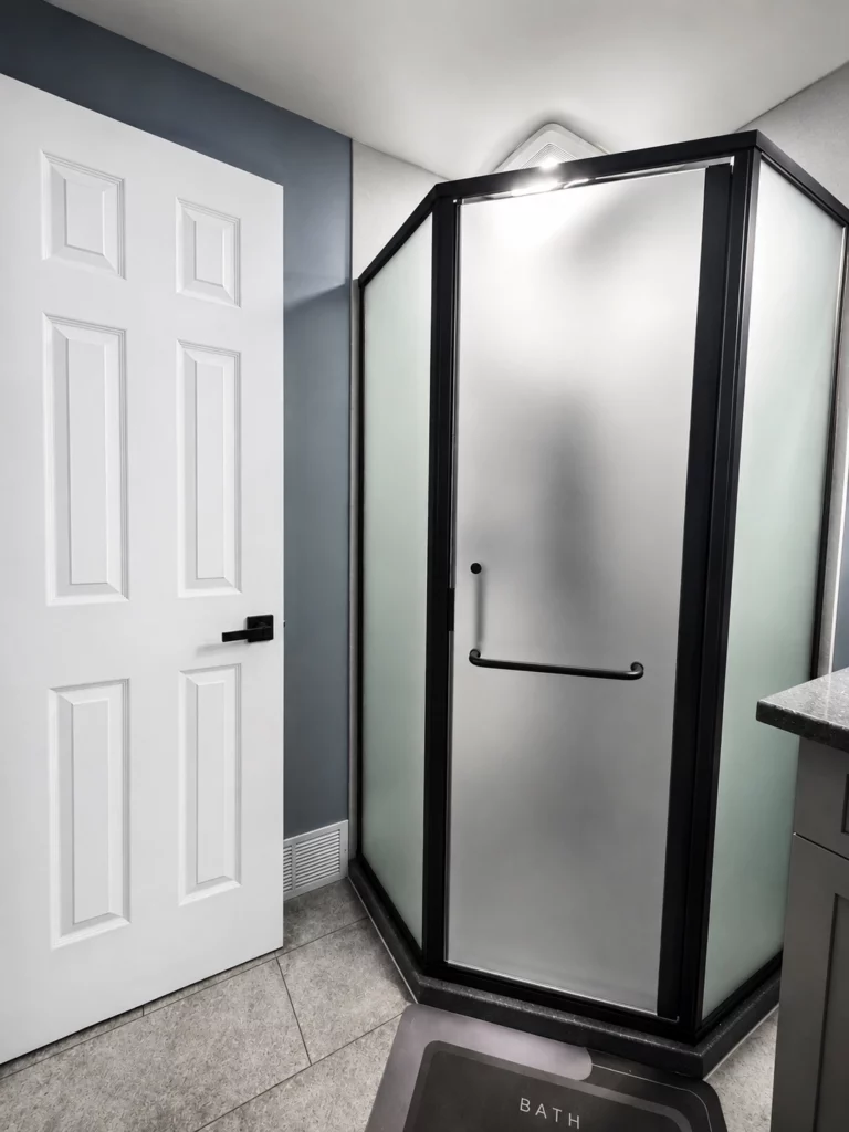 A completed neo-angle corner shower in Camillus NY with a custom satin glass door.